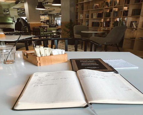 A notebook and pen on a coffee shop table