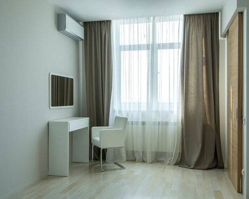 A bright, modern home office space with sheer curtains diffusing sunlight