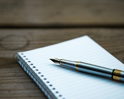 Close up of a warm desk lamp lighting up a notebook